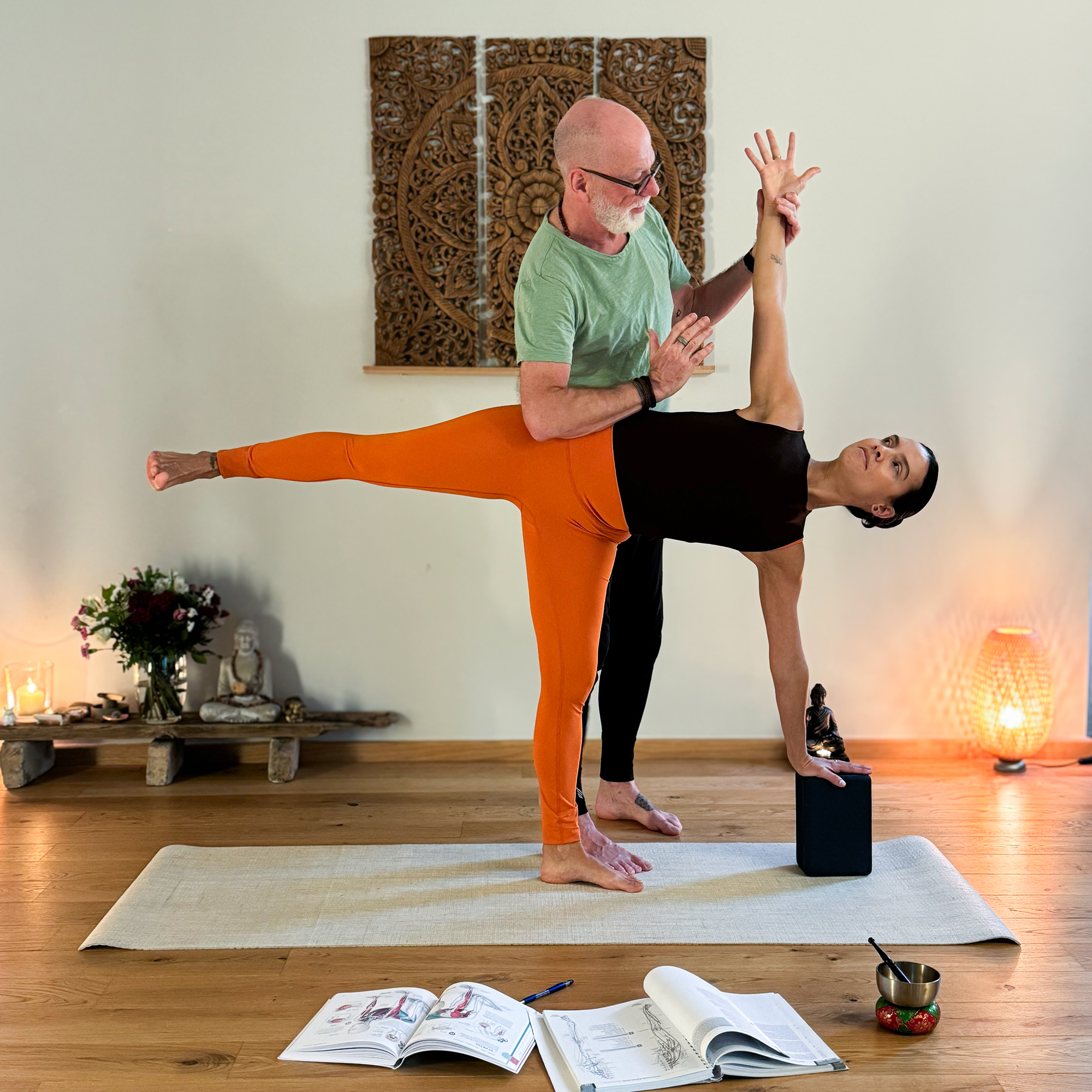 Ein Yogalehrer zeigt einen Assist in der Yogalehrer Ausbildung im YogaWerk Berlin-Tegel